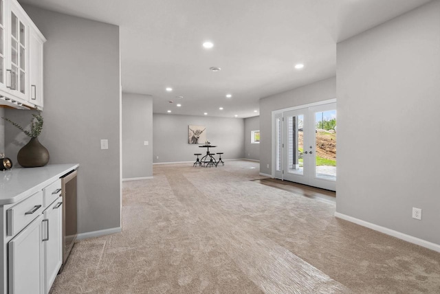 2352 Lonnie Ct, Sun Prairie, WI 53590 - kitchen with light carpet, white cabinetry, recessed lighting, baseboards, and glass insert cabinets