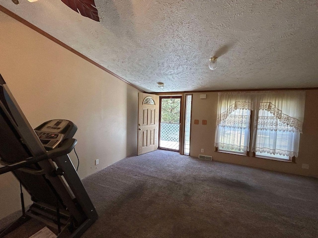 carpeted entrance foyer with crown molding and a textured ceiling