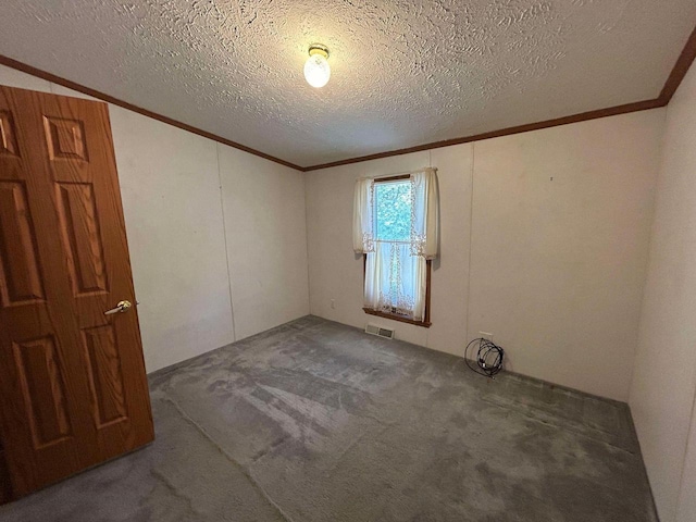 empty room with ornamental molding, dark colored carpet, and a textured ceiling