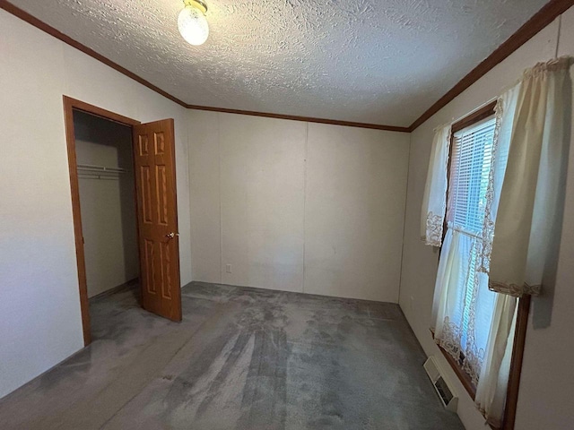 unfurnished bedroom with a closet, carpet flooring, ornamental molding, and a textured ceiling