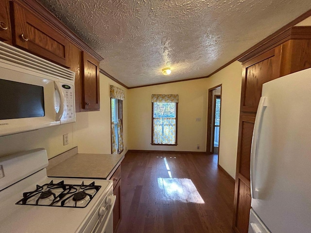 kitchen with lofted ceiling, white appliances, a textured ceiling, dark hardwood / wood-style floors, and crown molding