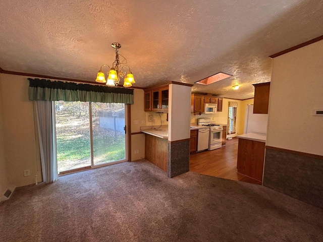 kitchen with white appliances, dark hardwood / wood-style flooring, a chandelier, ornamental molding, and a textured ceiling