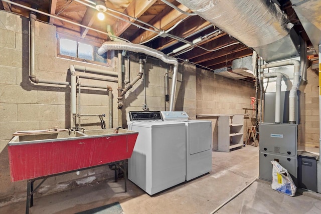 laundry room with heating unit, sink, and washer and clothes dryer