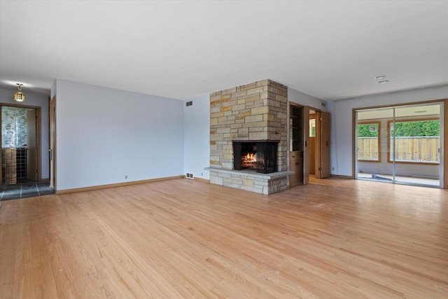 unfurnished living room with a fireplace and light wood-type flooring