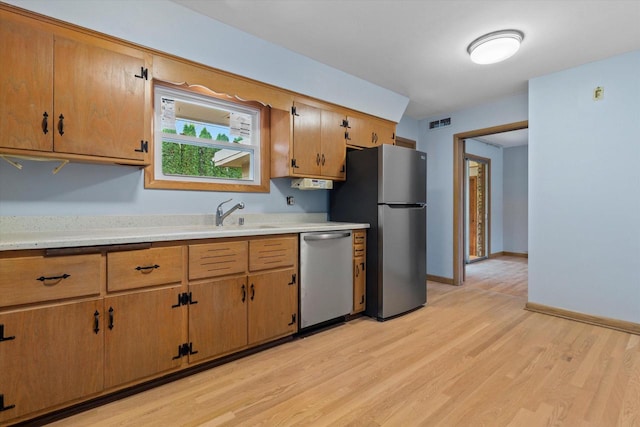 kitchen featuring appliances with stainless steel finishes and light hardwood / wood-style floors