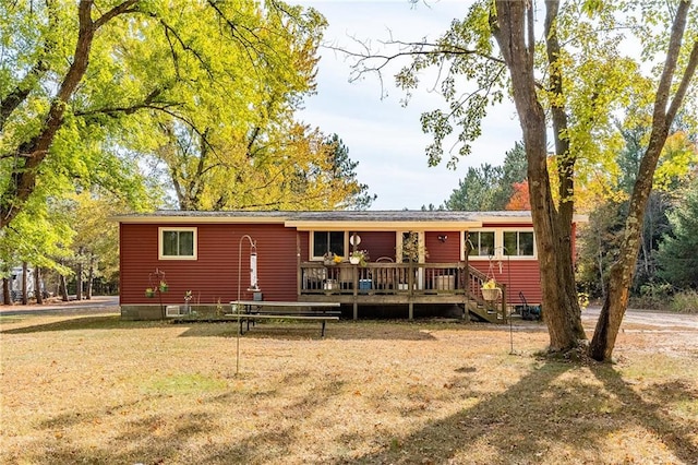 back of property with a wooden deck and a lawn