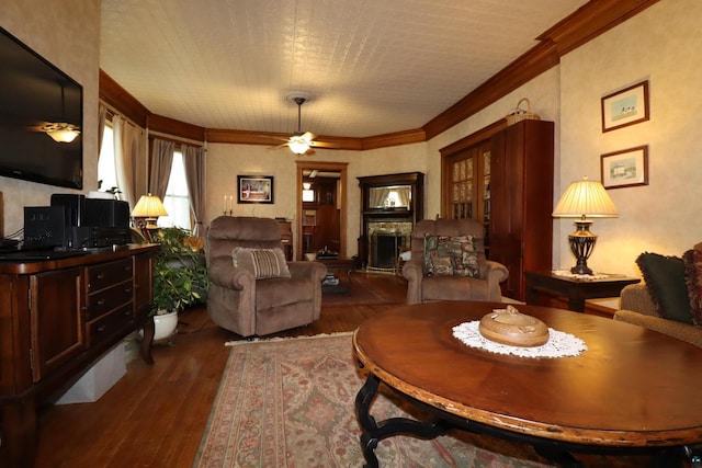 living room with ceiling fan, dark hardwood / wood-style flooring, and ornamental molding