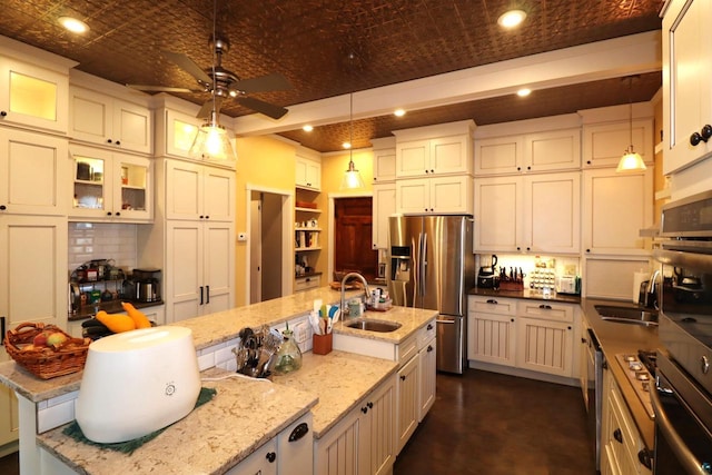 kitchen featuring brick ceiling, stainless steel appliances, dark stone countertops, hanging light fixtures, and sink