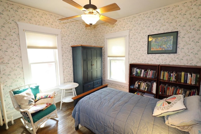 bedroom with ceiling fan, dark hardwood / wood-style flooring, and ornamental molding