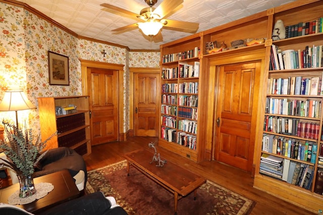 sitting room featuring ceiling fan, dark wood-type flooring, and ornamental molding