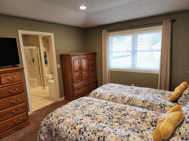 carpeted bedroom featuring vaulted ceiling and ensuite bath