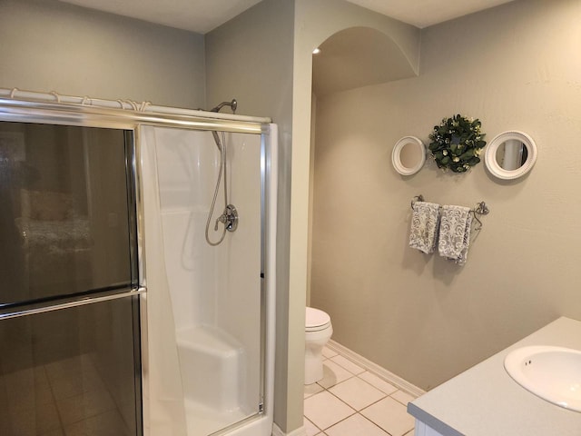 bathroom with tile patterned floors, vanity, a shower with door, and toilet