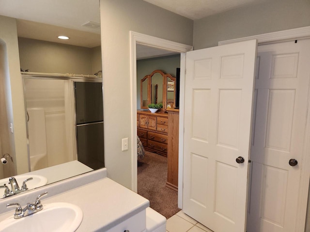 bathroom featuring a shower with door, tile patterned floors, and vanity