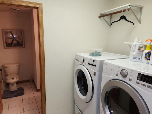 laundry room with independent washer and dryer and tile patterned flooring