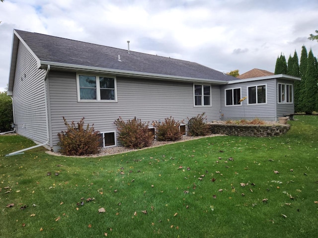 rear view of house featuring a lawn