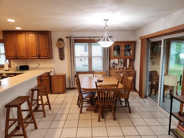 dining space with light tile patterned flooring, plenty of natural light, and a chandelier