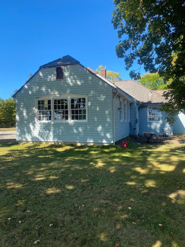 view of side of home with a yard