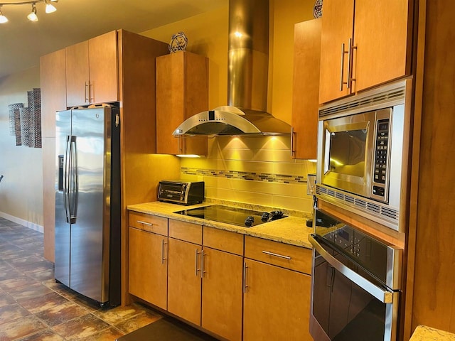 kitchen with appliances with stainless steel finishes, light stone countertops, wall chimney range hood, and backsplash