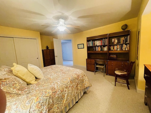 bedroom with ceiling fan, light colored carpet, and a closet