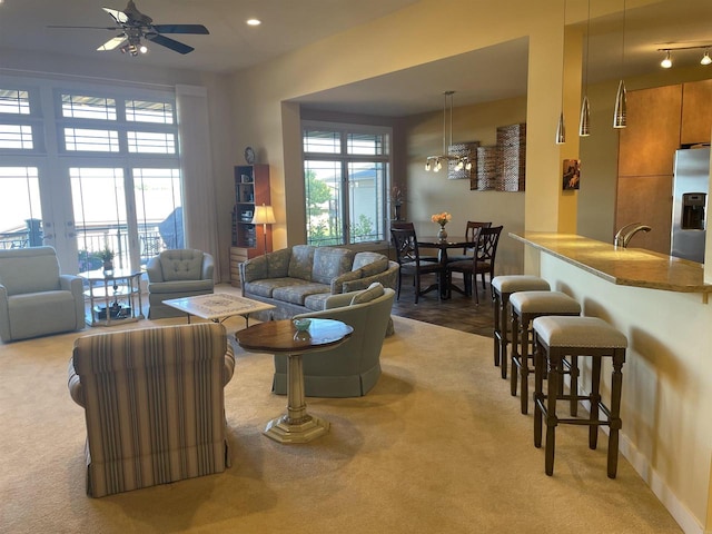 living room with light carpet, plenty of natural light, and ceiling fan