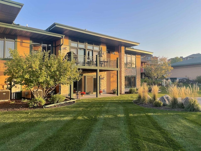 back of house with a yard, central AC, and a balcony