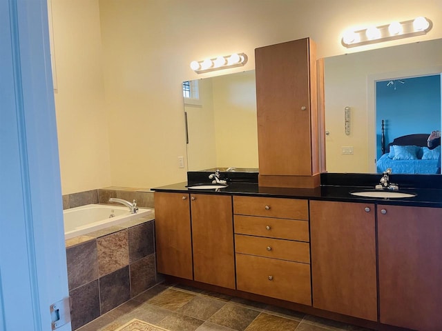 bathroom with tiled tub and vanity