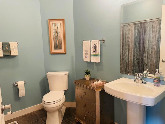 bathroom with tile patterned floors, toilet, and curtained shower