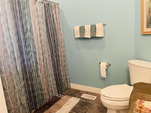 bathroom with tile patterned flooring, toilet, and curtained shower