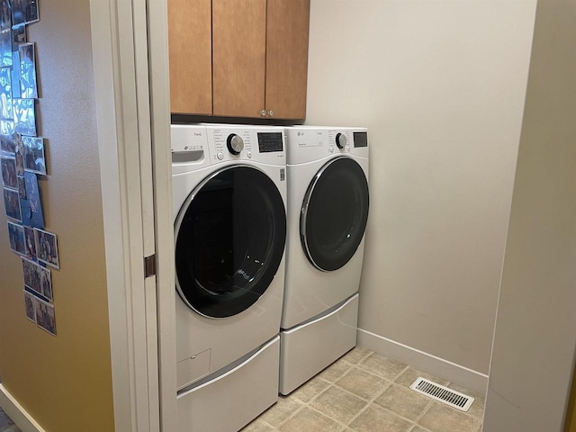 laundry room with cabinets and washing machine and dryer