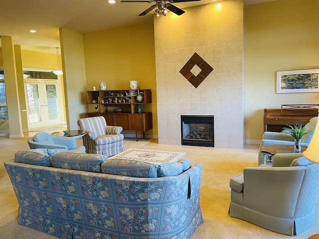 carpeted living room featuring ceiling fan and a fireplace