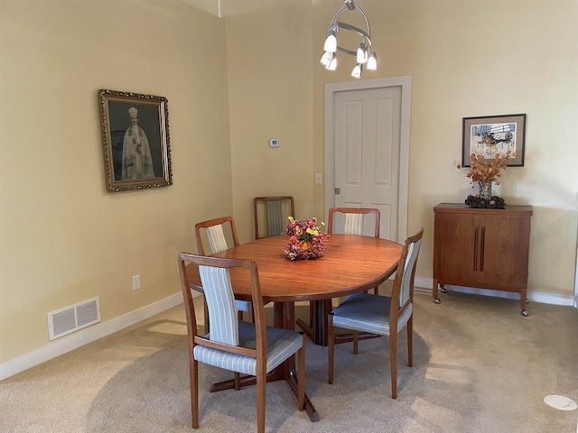 carpeted dining room featuring an inviting chandelier