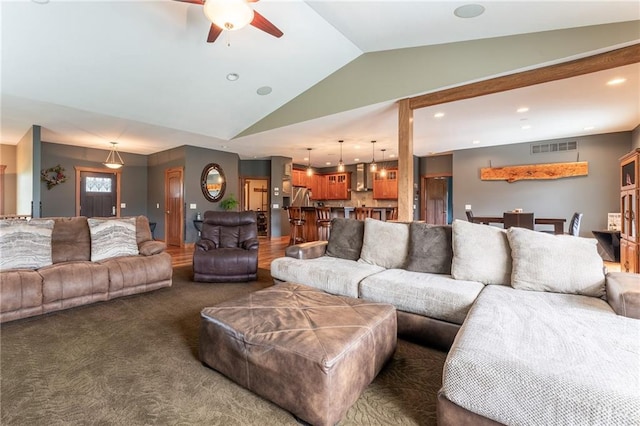 living room with ceiling fan, vaulted ceiling, and dark carpet