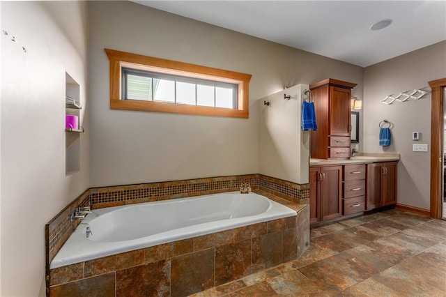 bathroom with vanity and a relaxing tiled tub