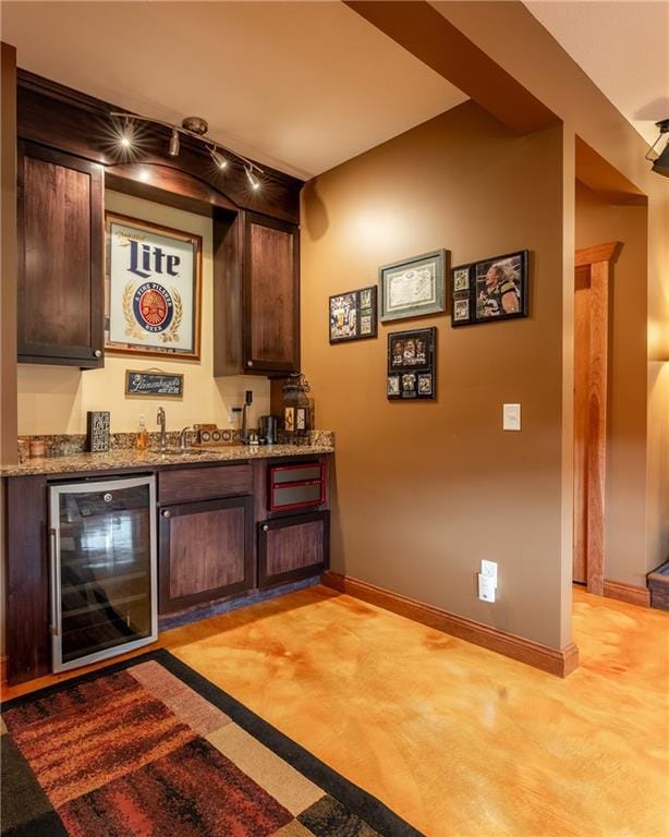 bar featuring light carpet, dark brown cabinets, wine cooler, and stone counters