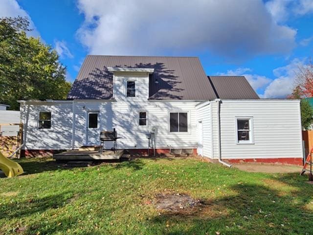 rear view of house with a wooden deck and a yard