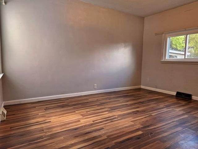 unfurnished room with dark hardwood / wood-style flooring