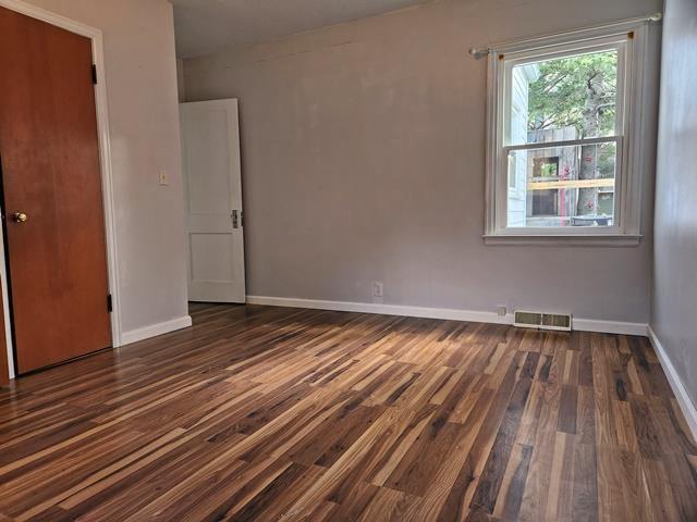 spare room with dark hardwood / wood-style flooring