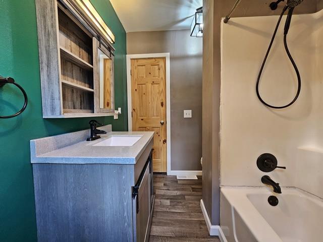 bathroom featuring shower / tub combination, vanity, and wood-type flooring