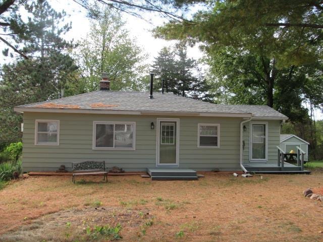 view of front of home with a wooden deck and a front lawn