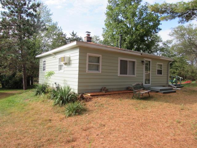 rear view of property featuring a lawn and an AC wall unit