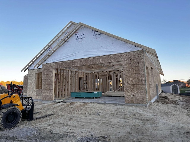 back of house featuring a storage shed