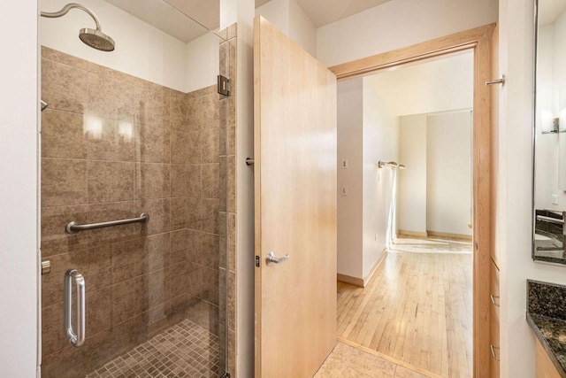 bathroom featuring vanity, wood-type flooring, and walk in shower