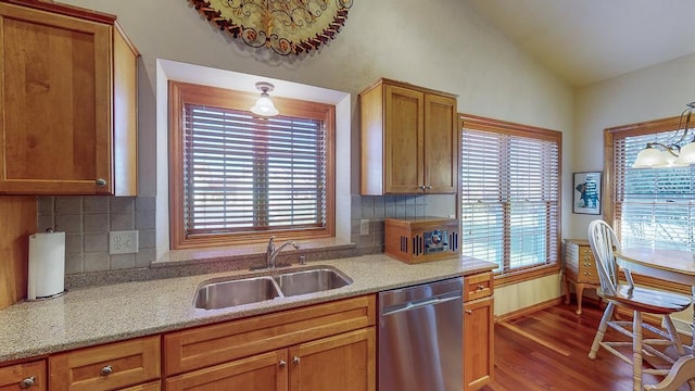 kitchen featuring dark wood-type flooring, lofted ceiling, sink, decorative light fixtures, and dishwasher