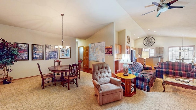 living room with ceiling fan with notable chandelier, light colored carpet, and high vaulted ceiling