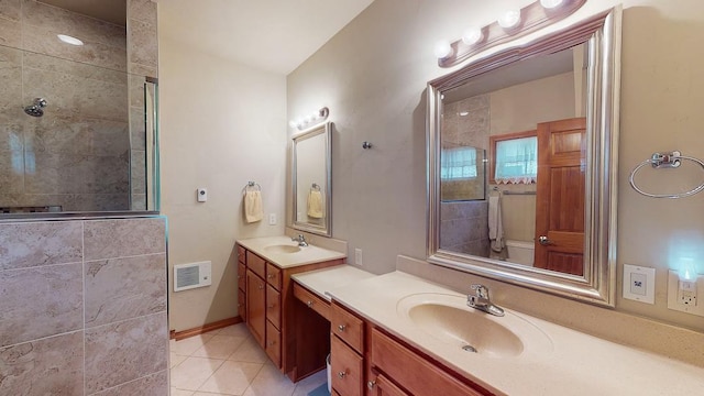 bathroom featuring a tile shower, vanity, and tile patterned flooring