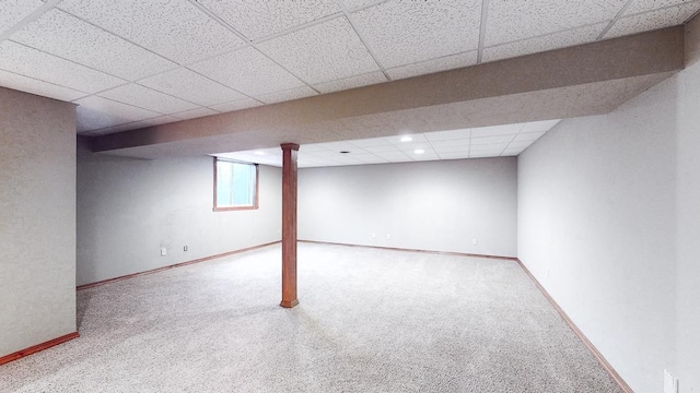 basement with carpet and a paneled ceiling