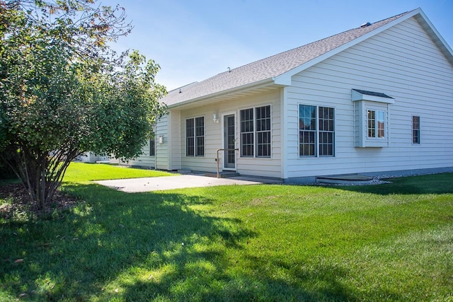 rear view of house with a yard and a patio area