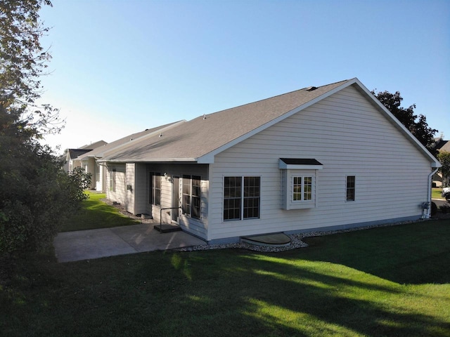 back of house featuring a patio area and a lawn