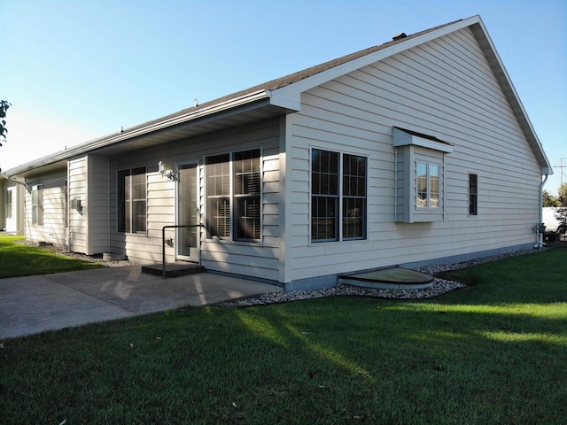 view of side of home featuring a yard and a patio area