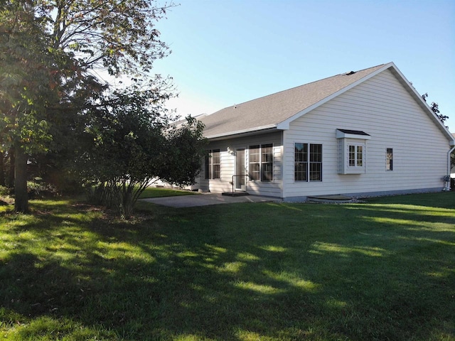 back of property featuring a patio area and a lawn